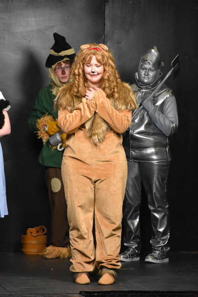 the lion singing while the cast looks on
