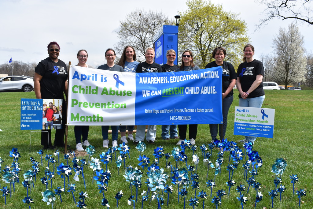 A group photo outside of the TECH Center behind their sign