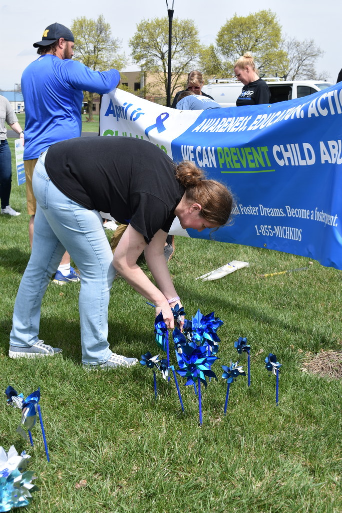 A person putting pinwheels in the ground