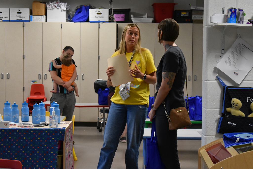 A teacher and parent chatting about the program