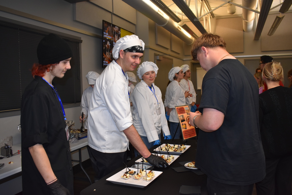 A student getting a dish while the team explains the item