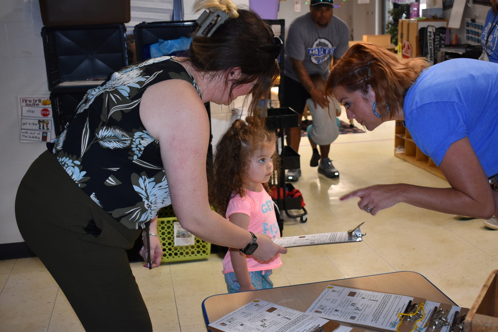 A child explaining something to a parent and child