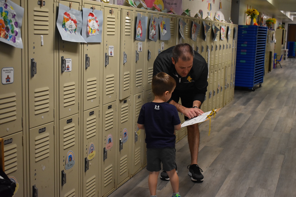A parent explaining something to his child near the lockers