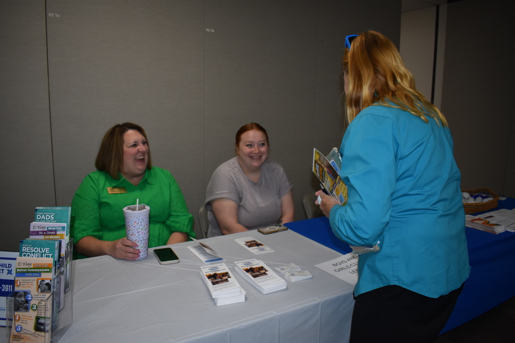 The Boys and Girls Club vendors speaking with an attendee at their table