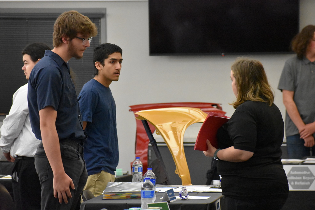 Two students speaking with a local employer