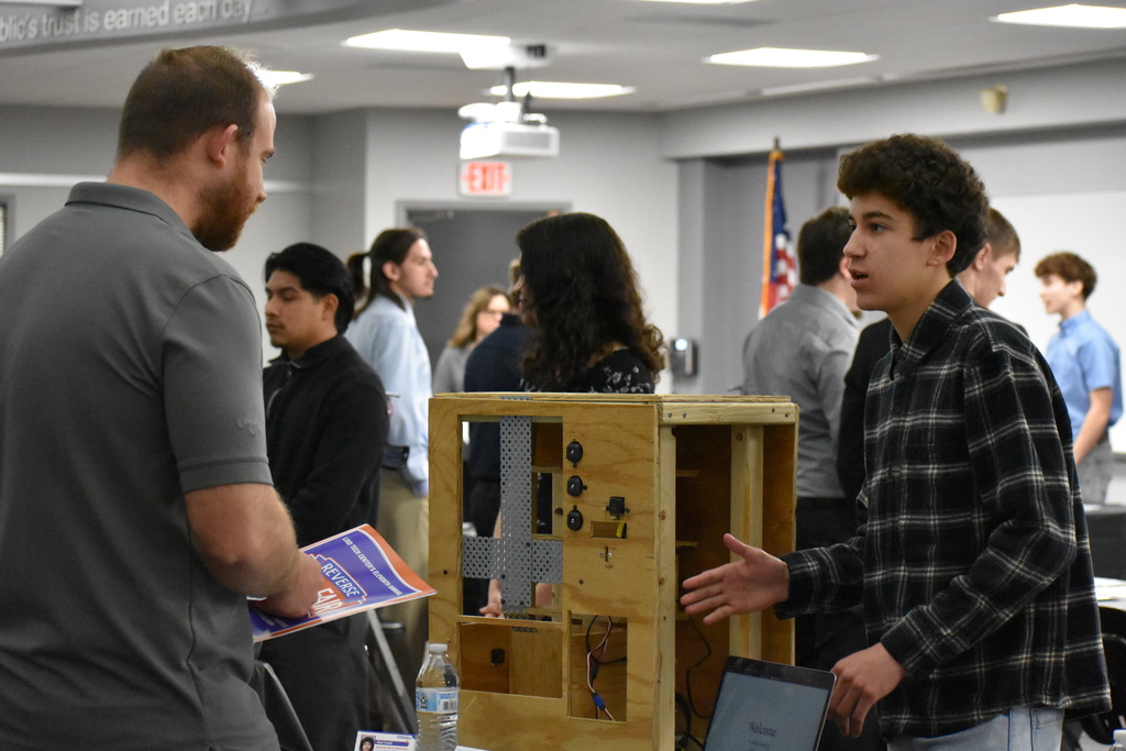 A student describing his work to an employer