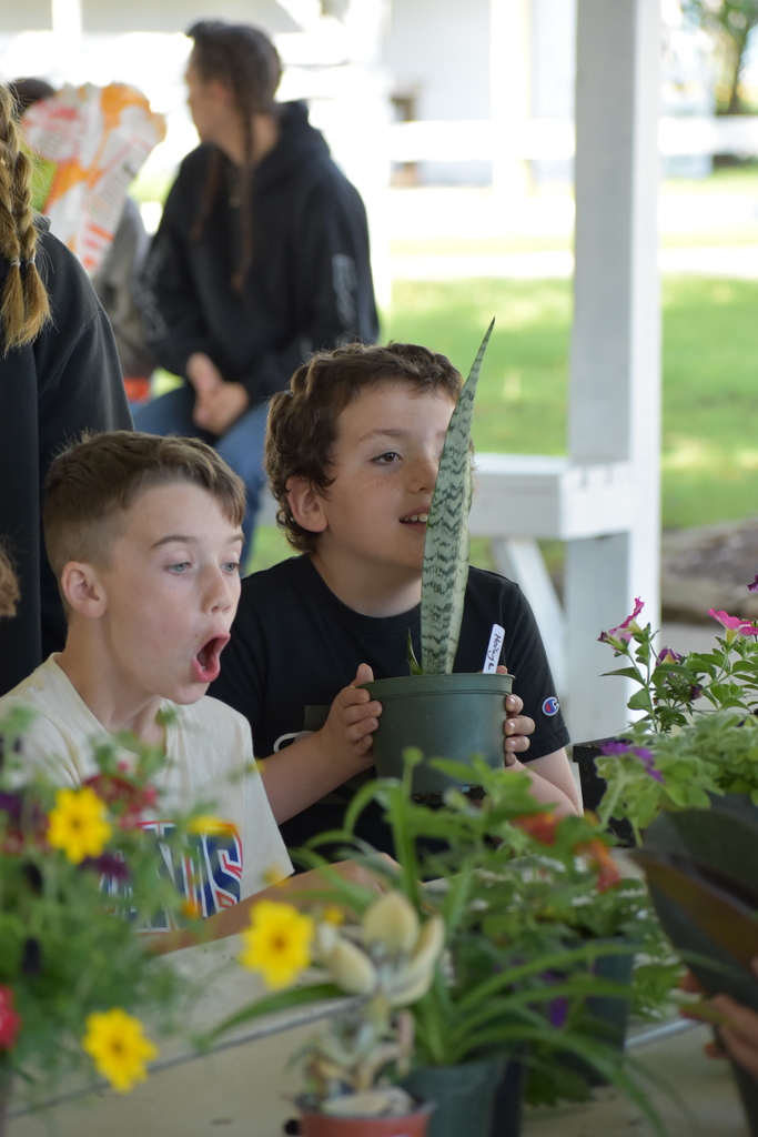 Two students smelling plants