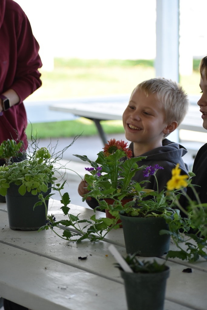 A young student smiling about something he learned related to plants