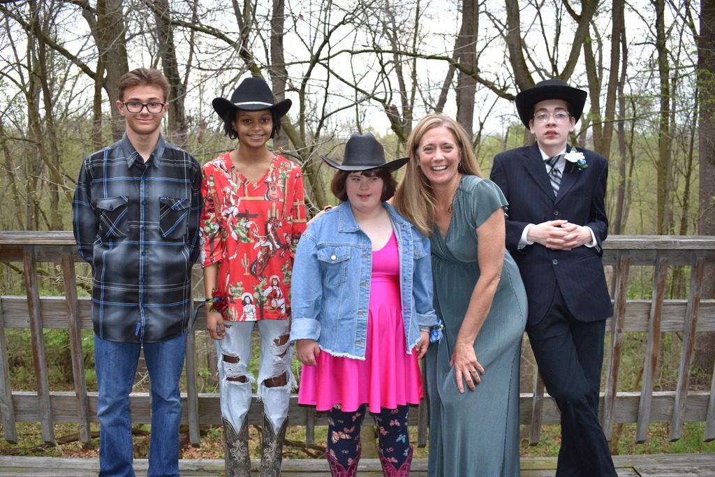 A teacher with her students posing for a photo at Prom