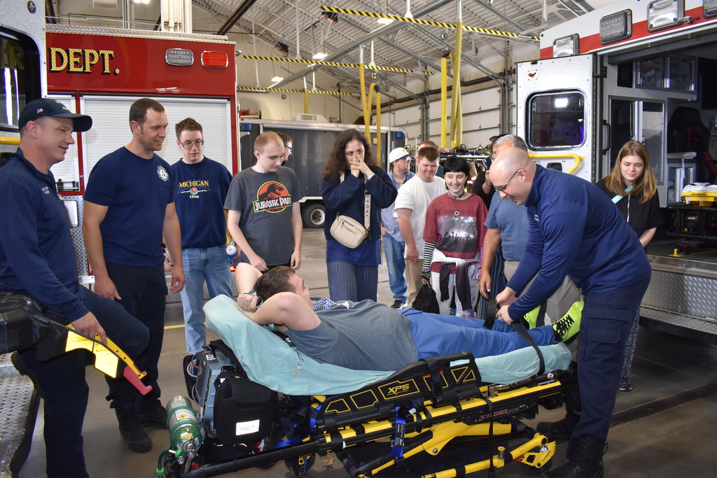 Students watching their classmate get put onto a stretcher