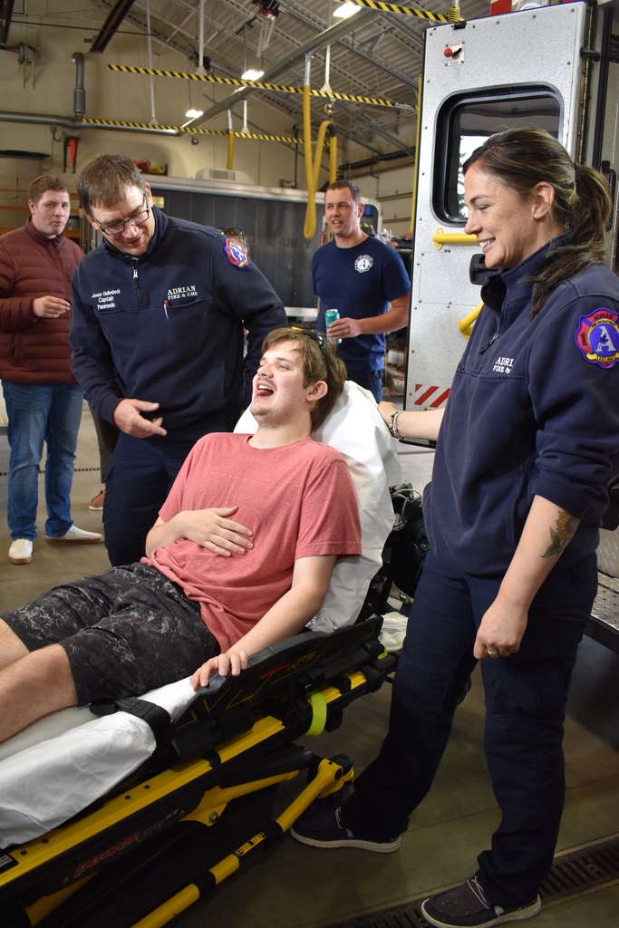 A student pretending to be sick while being placed on a stretcher