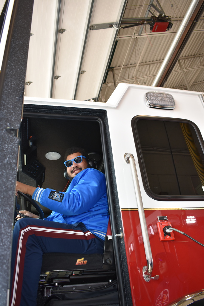A student smiling from a fire truck 