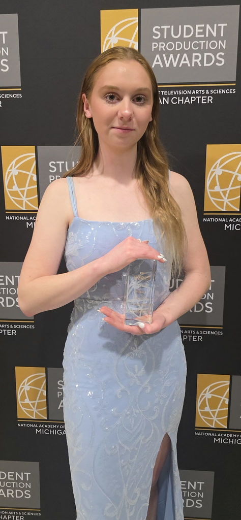A student posing with her award