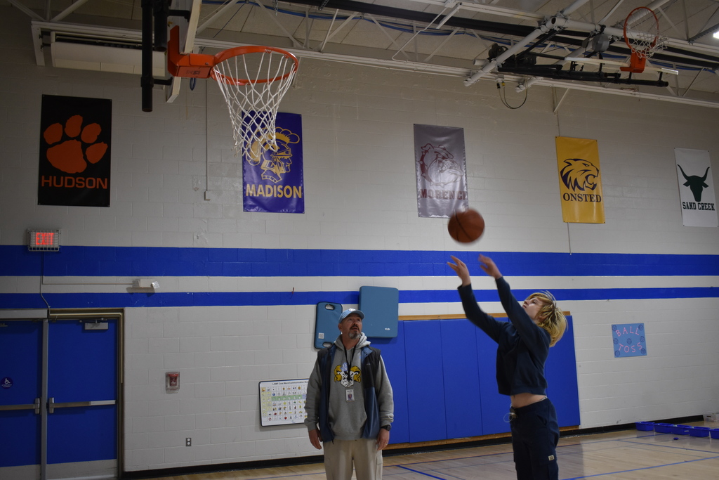 A student playing basketball with an instructor