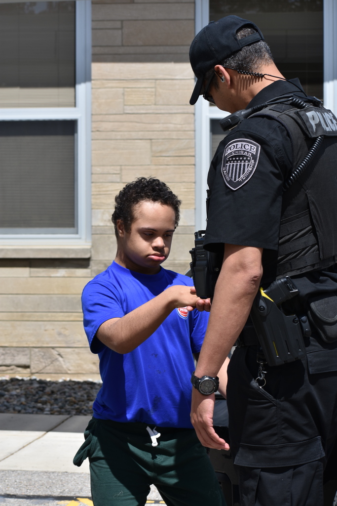 A student thanking a police officer by shaking his hand
