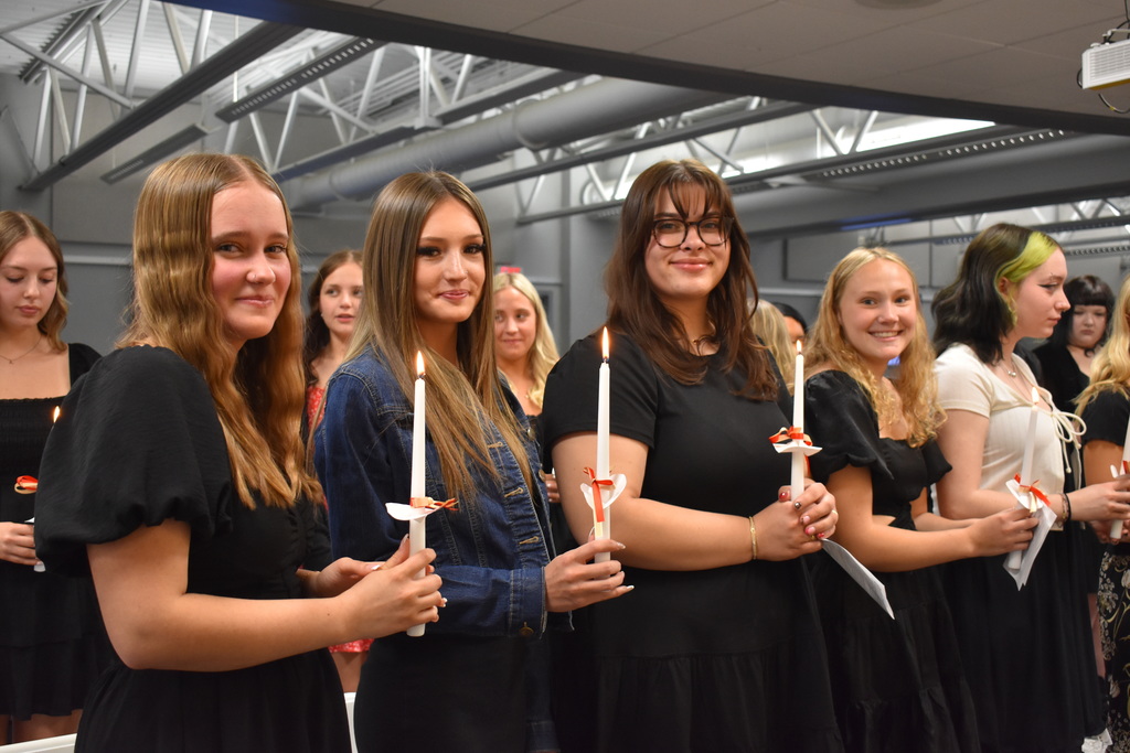 Four students holding their candles