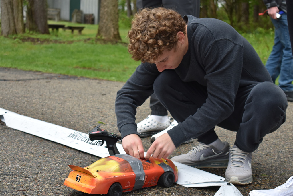 A student making a quick fix to his car that is on the track