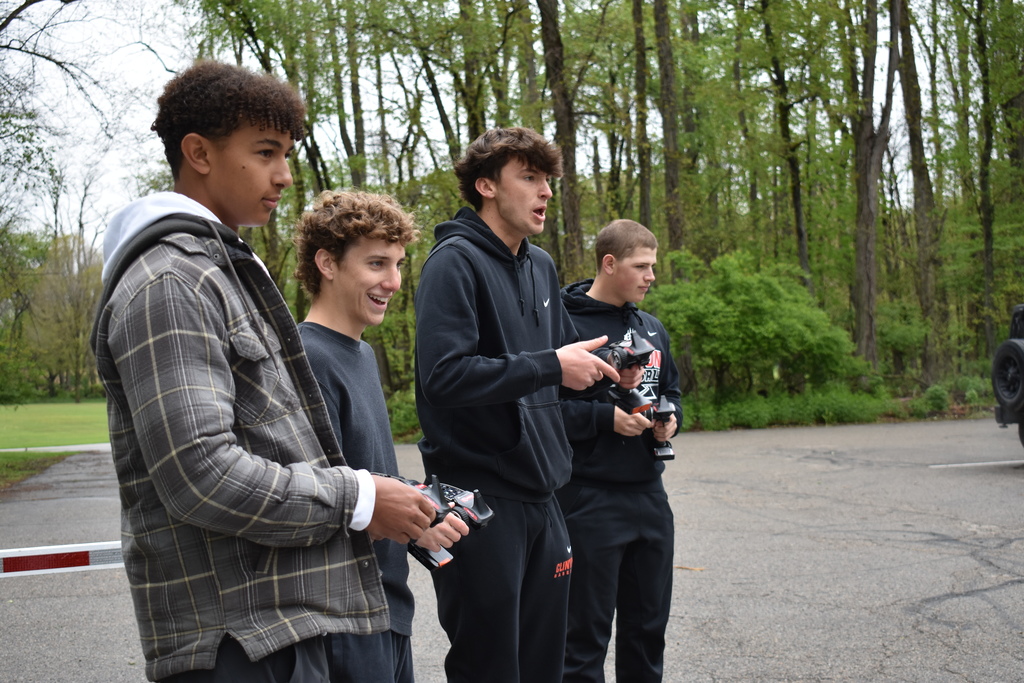 Four students racing and reacting to their cars on the track