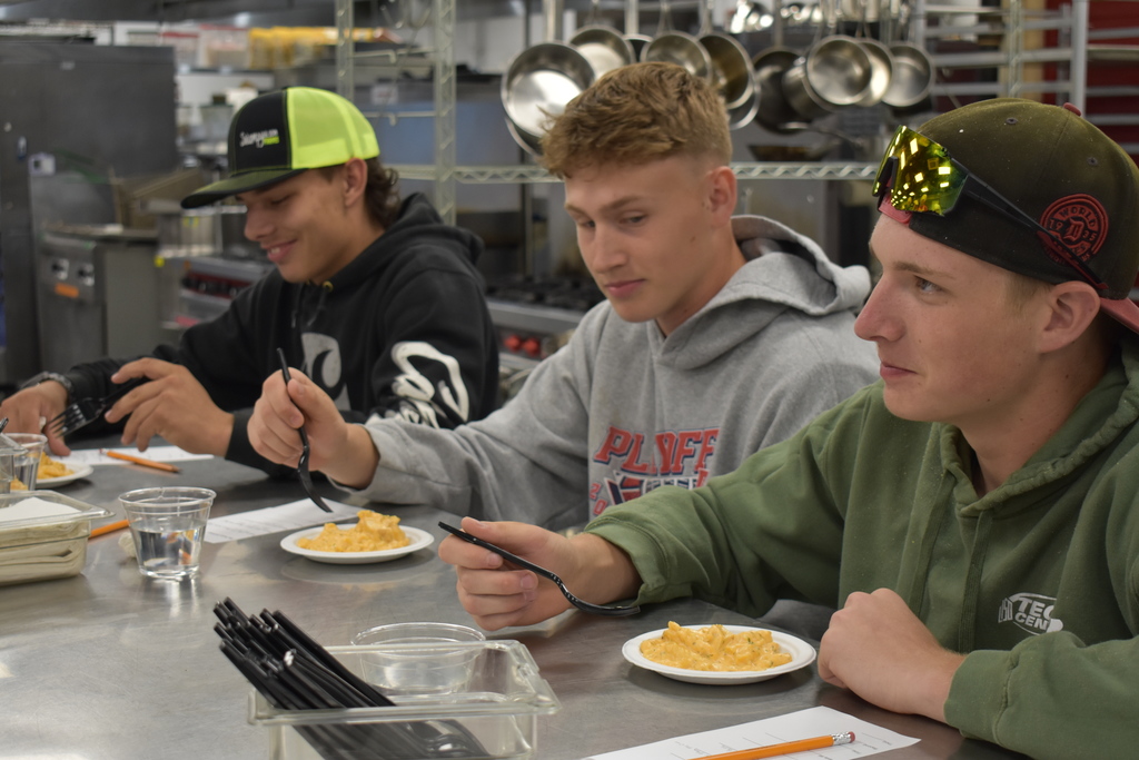 Two student judges trying one of the dishes