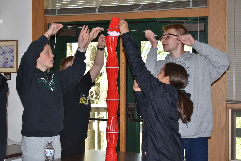Students trying to stack solo cups in an activity