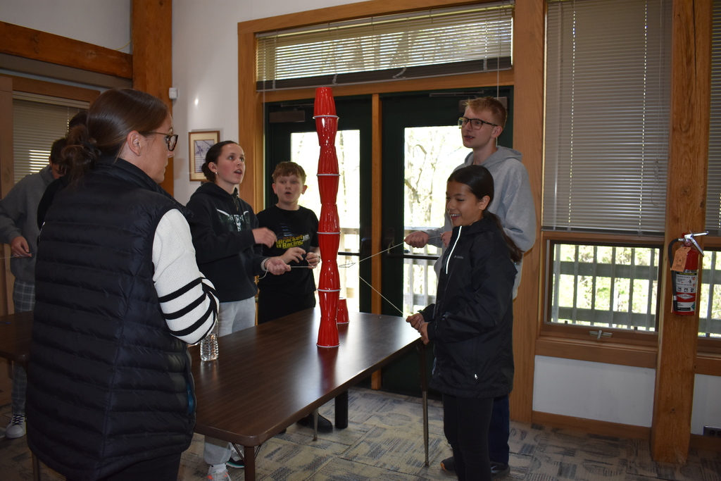 The students staking cups chatting with Erica Kranz about the next steps