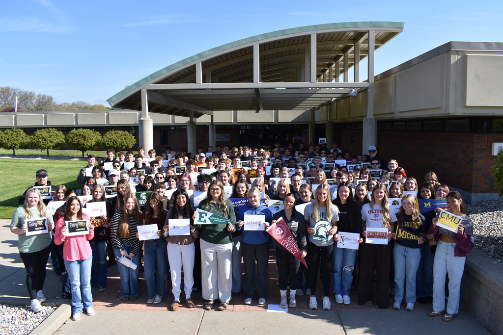 Our AM students positioned in front of the TECH Center holding signs of where they are going after graduation