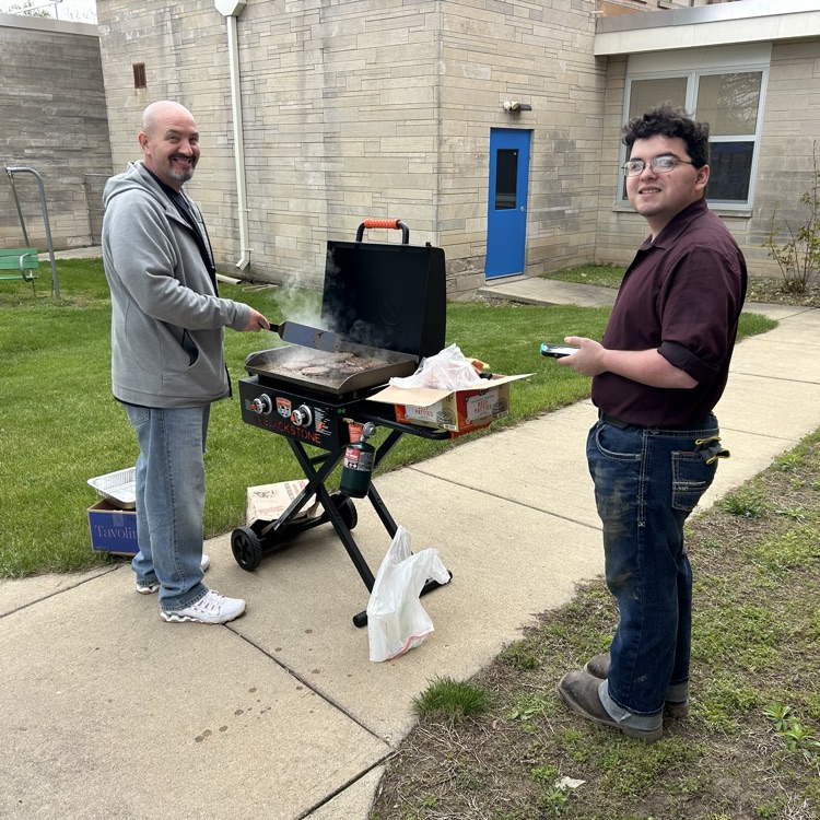 a staff member and student grilling 