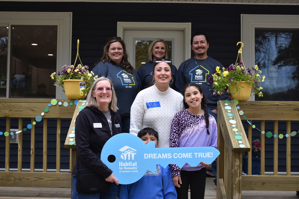 The Lenawee County Habitat for Humanity team with the family on the front porch of the home