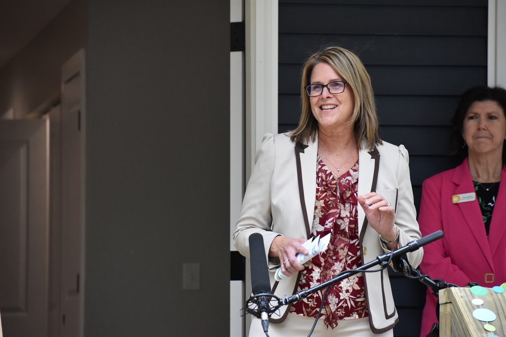 Assistant Superintendent Jenny Heath speaking on the porch into a mic