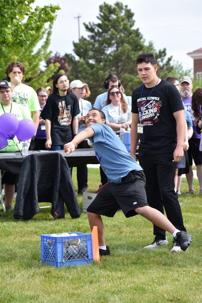A student throwing a ball while a crowd looks on