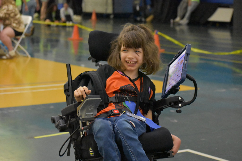 A student smiling as she moves across the gym floor