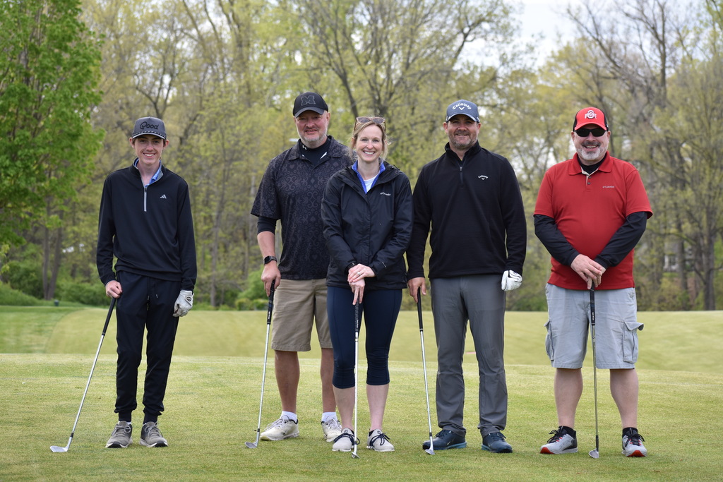 A team on the golf course posing for a photo