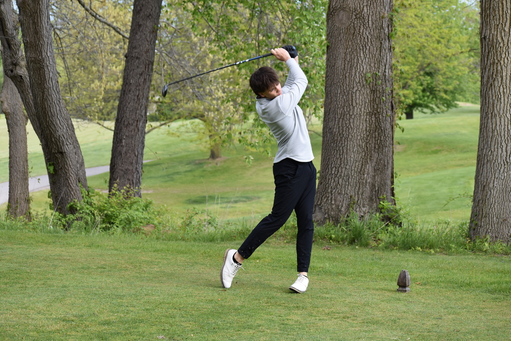 A golfer driving the ball on the course