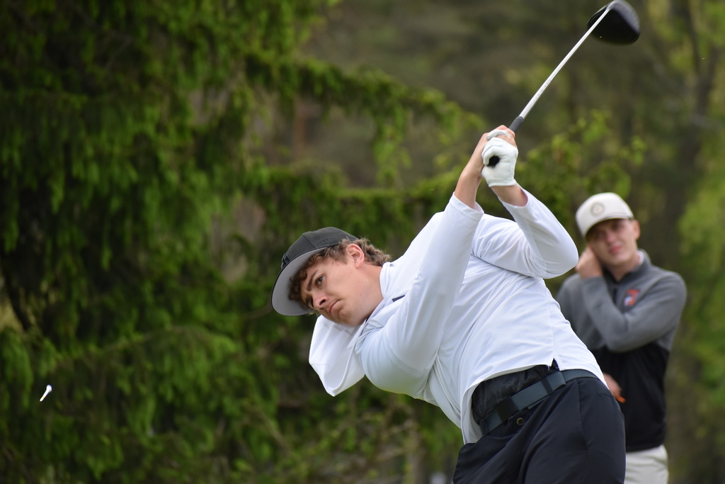 A golfer mid swing on the course