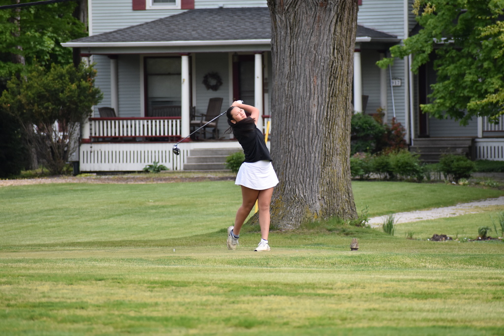 A golfer mid swing on the course