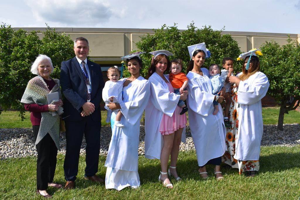 The graduates with Mrs. Ross and the superintendent posing outside