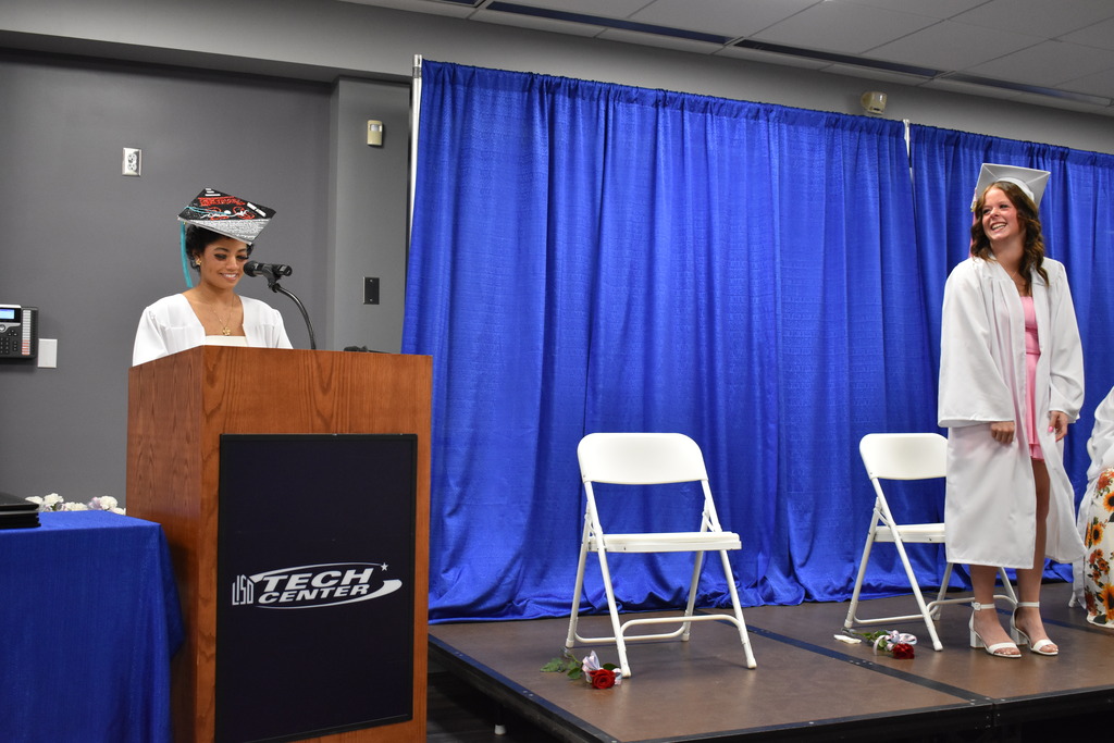 A graduate speaking about her fellow graduate to honor her