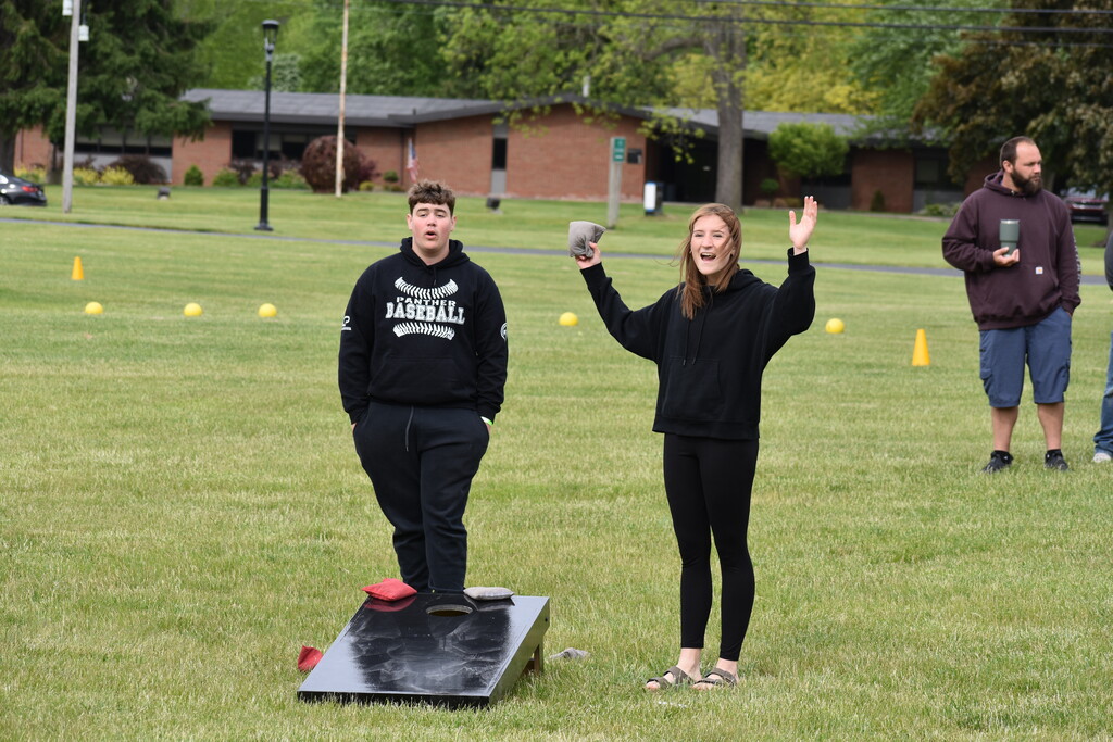 Two surprised reactions during a game of cornhole