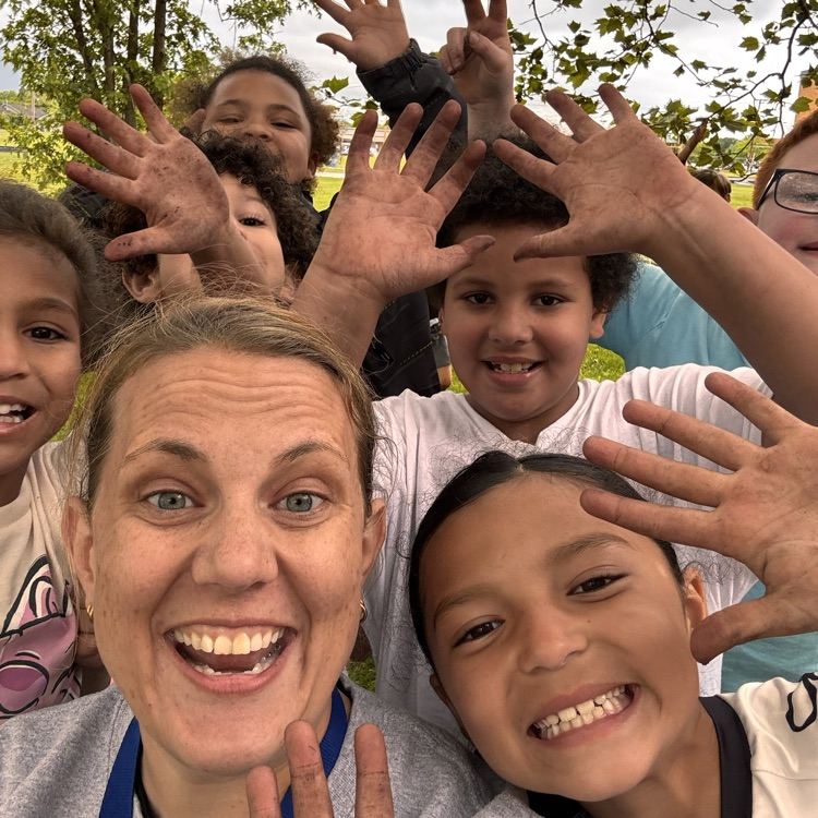 LISD employee with a group of students smiling and showing their dirty hands