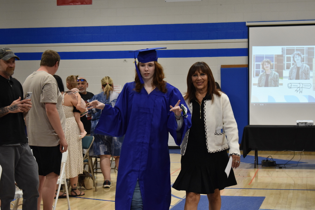 A graduate and her teacher walking in