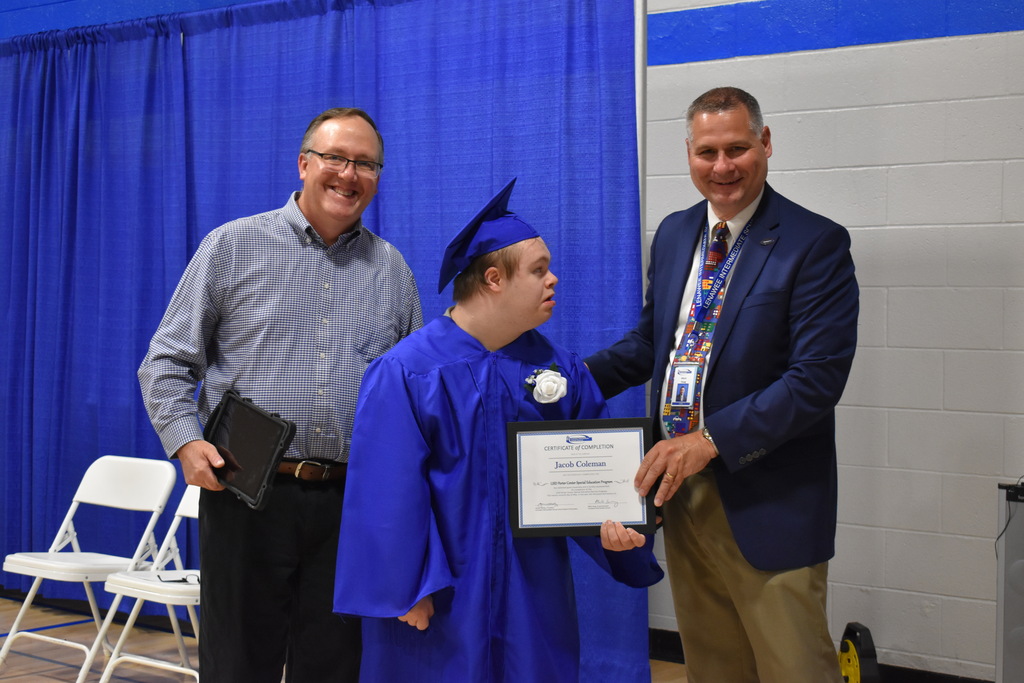 A graduate with two staff members