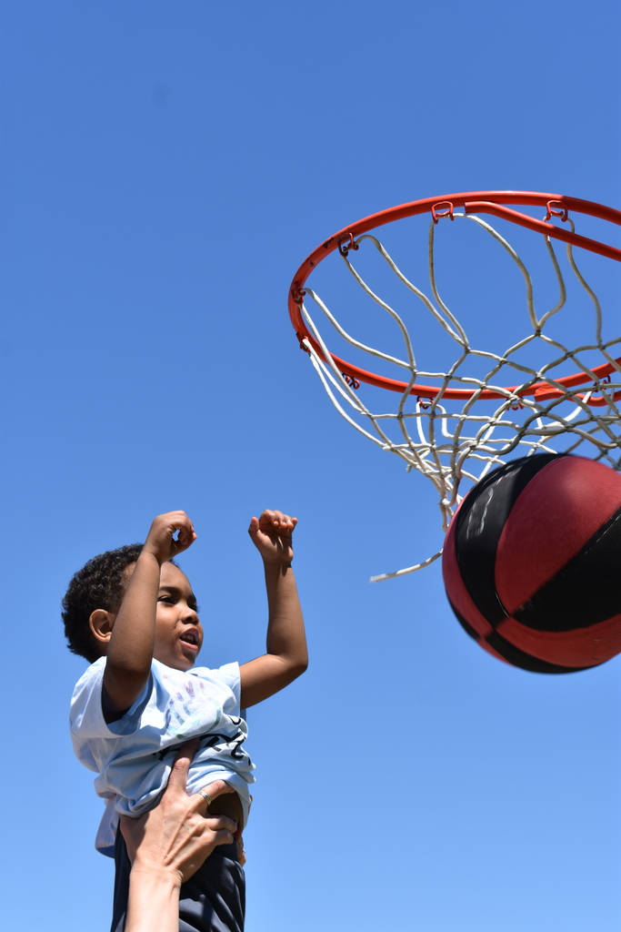 One of the students' kids making a basketball shot
