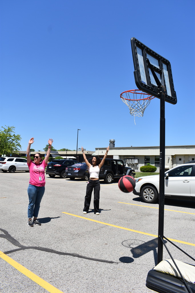 A teacher and student celebrating a basketball shot