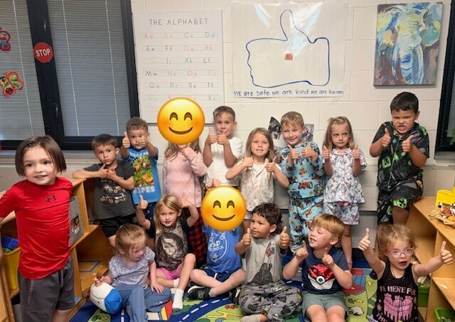 students giving thumbs up
