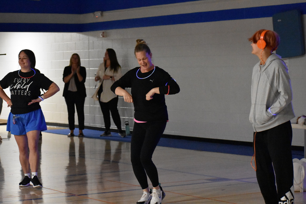 A student and two teachers dancing