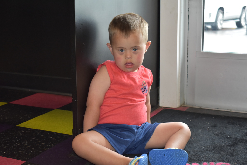 A child sitting on the floor and looking at the camera