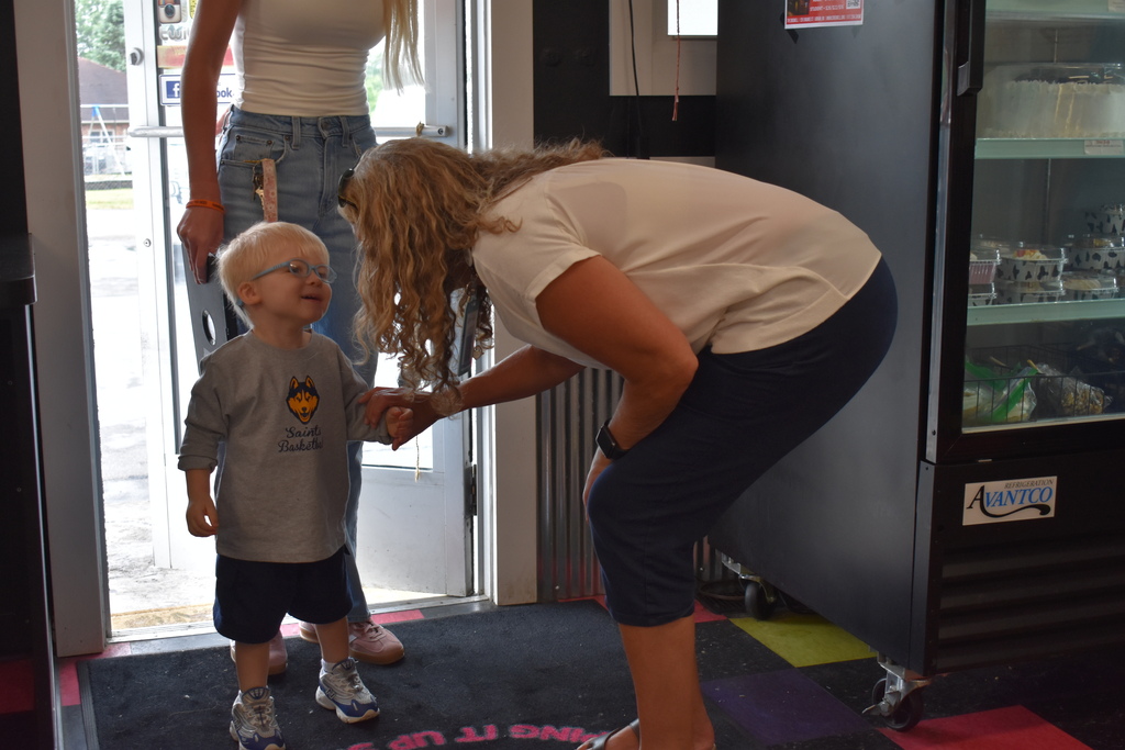 A child being greeted by an LISD employee at the spotted Cow