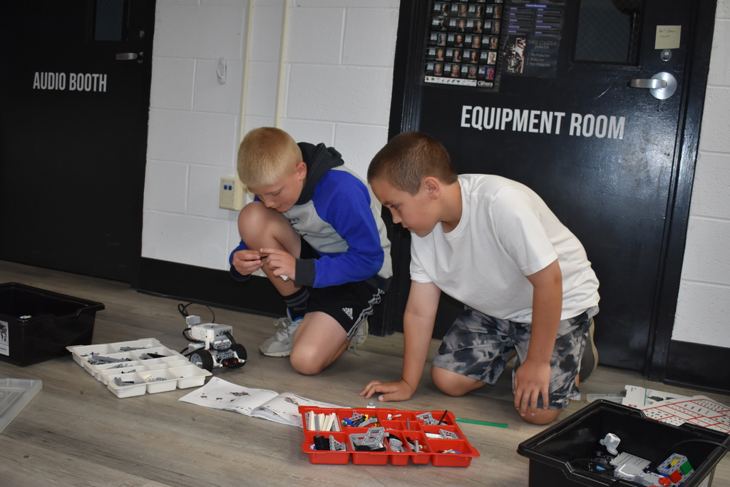 Two boys working on building a robot