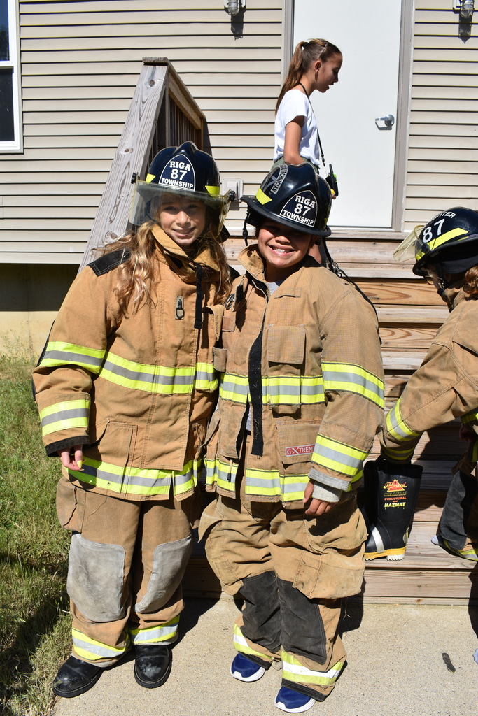 Two female junior firefighters posing for a photo in their gear