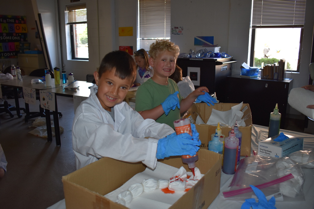 Two young kids tiedying a shirt